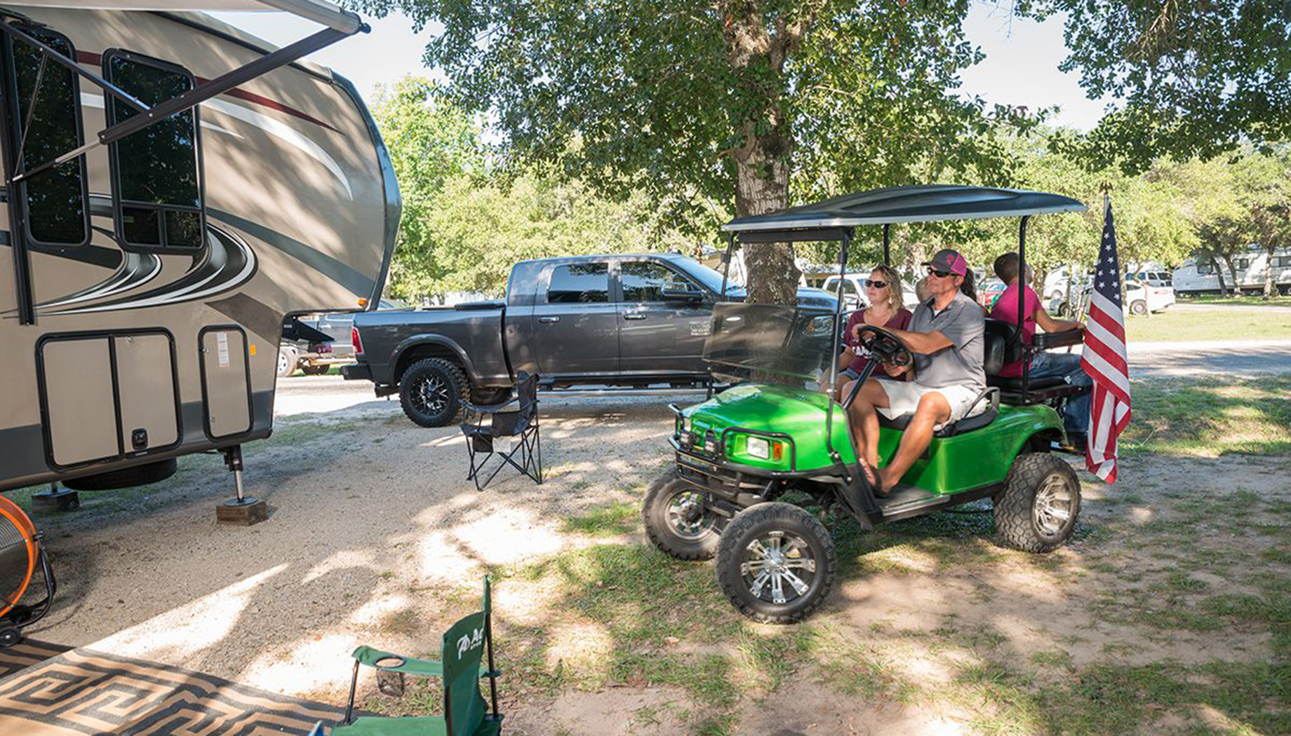Family driving to their RV in a bright green golf cart.