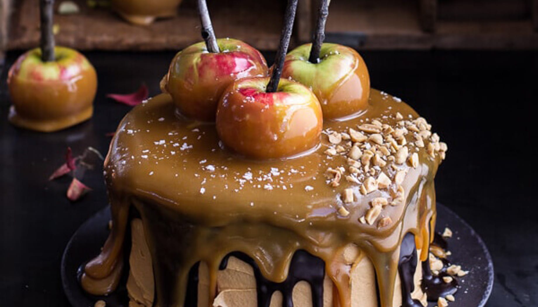 Cake with gooey caramel flowing over the edges and caramel apples on top.