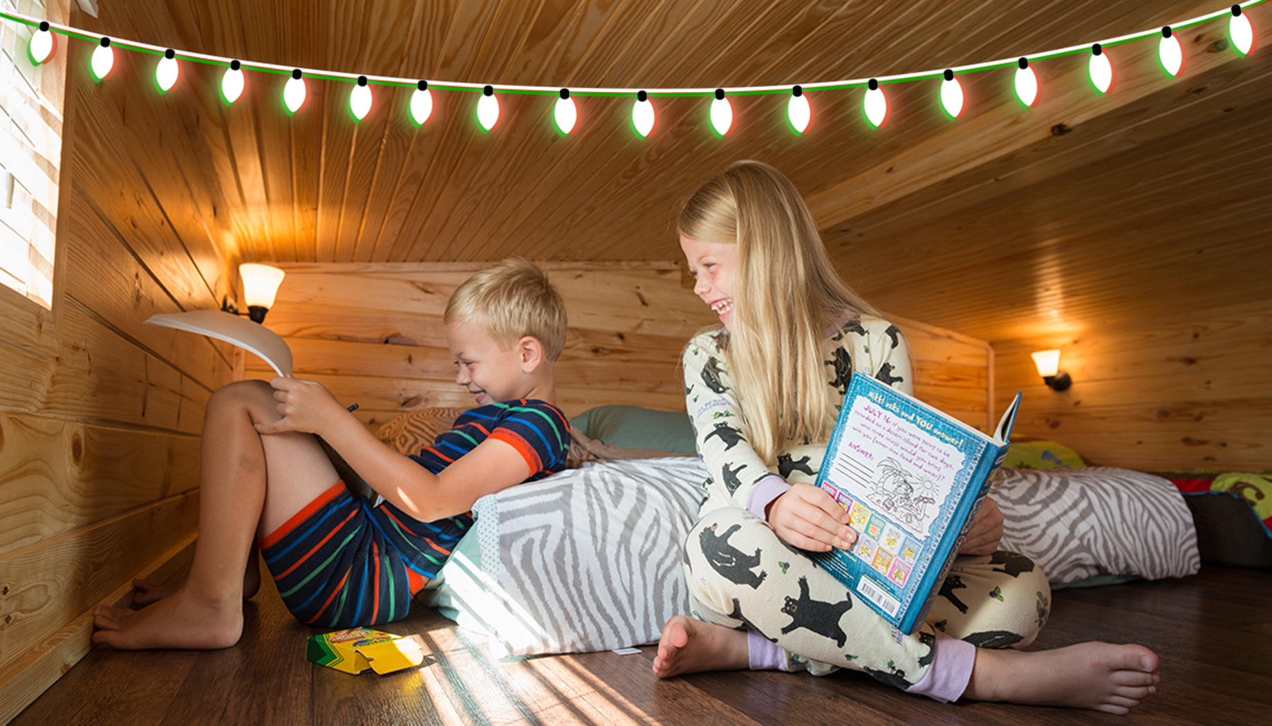 Girl reading a book and boy coloring with crayons in a Splashway Campground cabin.