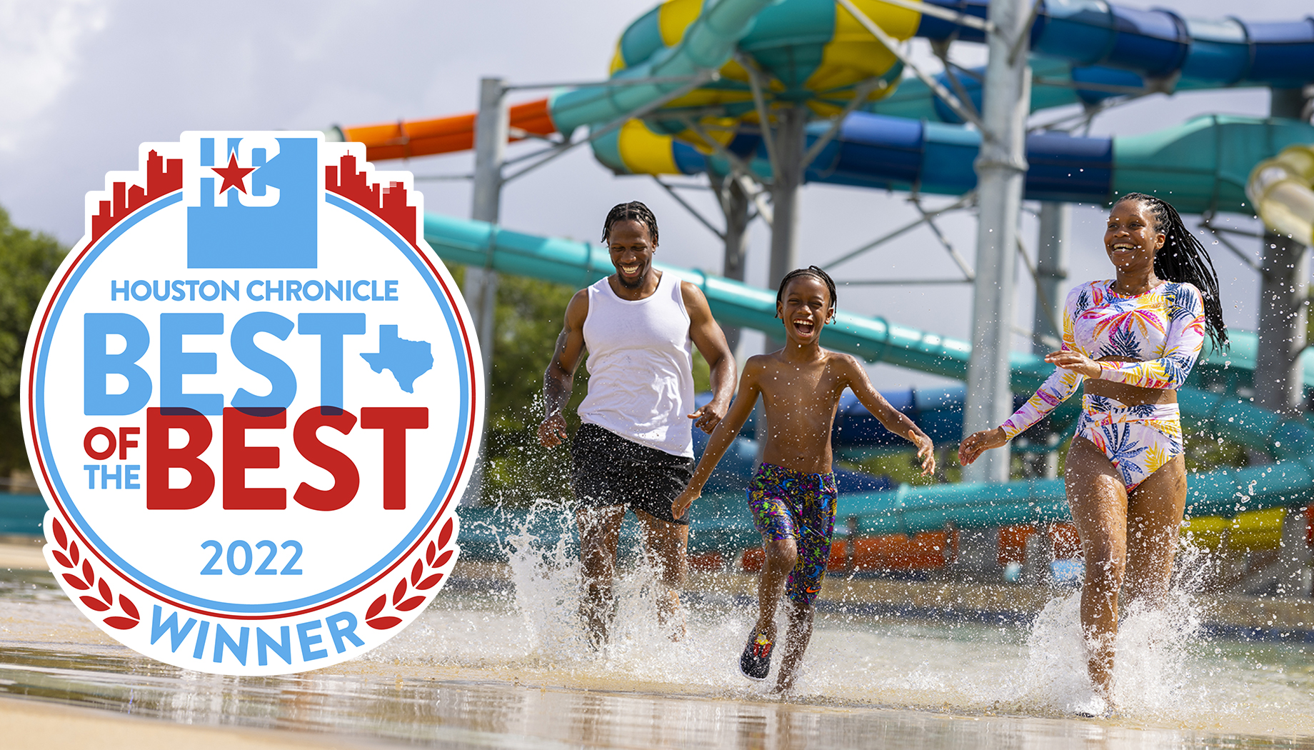 A family of three runs through water at a waterpark. The image includes a Houston Chronicle "Best of the Best 2022 Winner" badge.